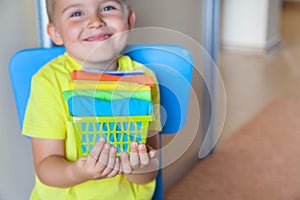 The child keeps his things. The boy puts the T-shirts in a drawer.