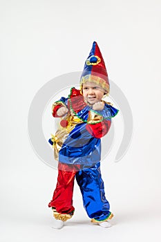 Child kid boy preschooler in Harlequin, Arlecchino, Arlequin, costume dancing. Vertical shot isolate on white background. Concept photo