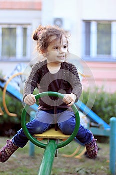 Child kid girl swinging on a playground swing