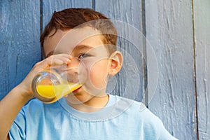 Child kid little boy drinking orange juice drink outdoor copyspace copy space outdoors outside