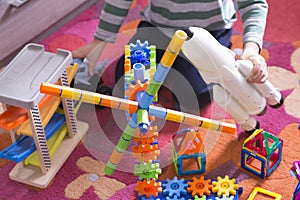 Child or kid playing in his room with educational toys on a carpet