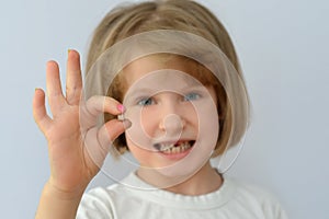 Child, kid, shows the fallen baby tooth.