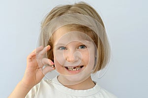 Child, kid, shows the fallen baby tooth.