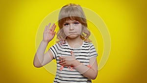 Child kid swear to be honest, aising hand to take oath promising to tell truth keeping hand on chest