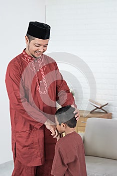 Child kissing his father`s hand to apologize