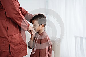 Child kissing his father`s hand to apologize