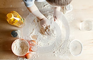 The child on the kitchen kneads the dough