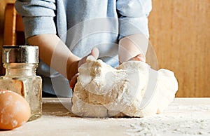 The child on the kitchen kneads the dough