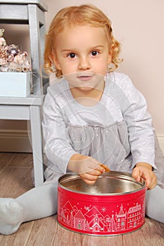 Child in the kitchen sitting and eating cookies in the shape of a rectangle