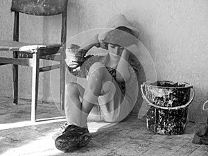 Child labour concept. Tired boy painter is very tired after work.Tired schoolchild in shirt sleeping on the floor. Black and white