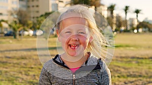 Child, laughing and face and windy hair in city park, garden or Denmark travel location for summer break, school trip or