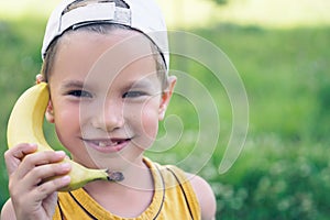 Child laughing while playing pretend with a wooden banana phone