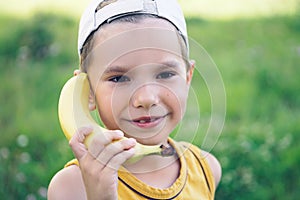 Child laughing while playing pretend with a wooden banana phone