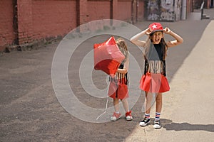 The child laughs merrily putting a cap on his head. The girl holds a balloon in the shape of a star in her hand. photo