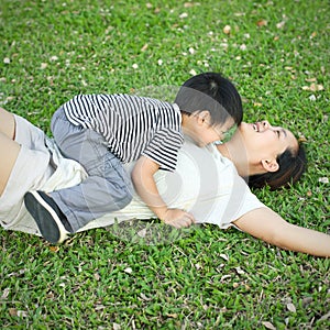 Child laying on young mother in meadow