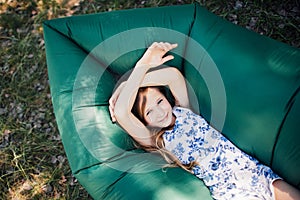 A child lays on a resting on an air sofa in the forest. Lamzac. Travel, family vacation in the forest in summer