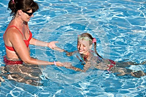 Child learn swim in swimming pool.