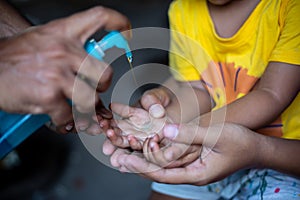 A child is learning how to clean hands with liquid cleaning gel.