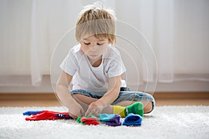 Child learning how to put in pairs different socks, kid sitting on the floor and playing with socks