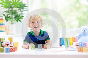 Child learning letters. Kid with wooden abc blocks