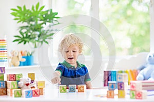 Child learning letters. Kid with wooden abc blocks