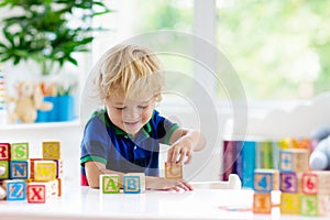 Child learning letters. Kid with wooden abc blocks photo