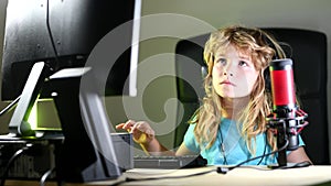 Child learning online at night, using desktop computer in living room at home, gaming on a desktop computer pc. Social