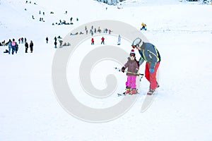 The child learning to ski and man on the slope