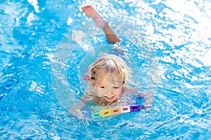 Child learning to swim. Kids in swimming pool