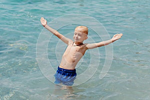 Child learning to swim in the open sea of tropical resort. Kids learn swimming. Exercise and training for young children