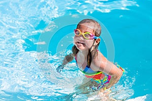 Child learning to swim in pool