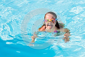 Child learning to swim in pool