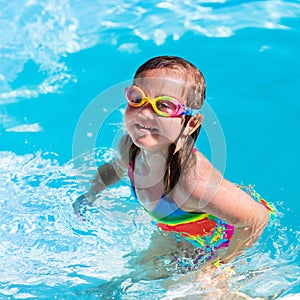 Child learning to swim in pool