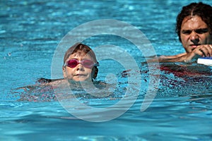 Child learning to swim, swimming lesson