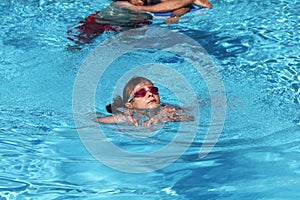 Child learning to swim, swimming lesson