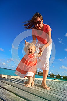 Child learning to walk on beach vacation