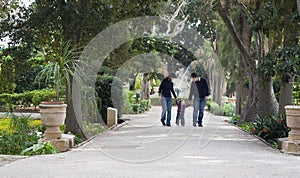 Child learning to walk with parents