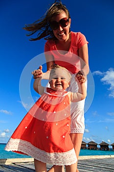 Child learning to walk on tropical vacation