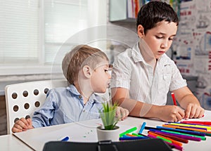 The child learns at home. Happy children draw in the classroom.