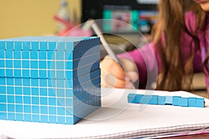 Child learns math, volume and capacity. For learning model uses a three-dimensional cube. photo