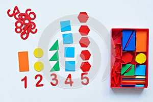 The child learns Number line and geometric shapes. The preschooler works with Montessori material. Educational logic toys for kid photo