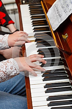 A child learns to play the piano in a music studio with a teacher.