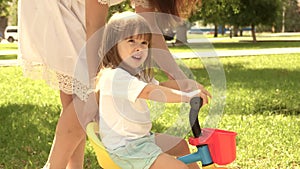 The child learns to ride a bike. Mom teaches little daughter to ride a bike. Happy family and healthy childhood. Mother