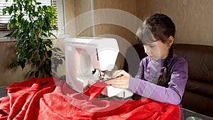 The child learns to sew on the sewing machine.