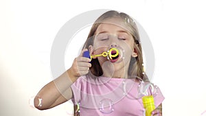 Child lets the soap bubbles. White background. Slow motion