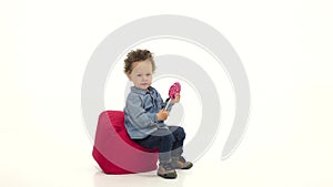 Child licks a tasty, sweet candy. White background. Slow motion