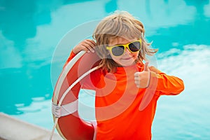 Child with Lifebuoy in swimming pool. Children playing in the pool. Healthy kids lifestyle. Summer kids vacation.