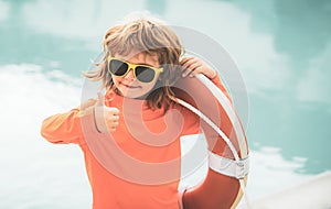 Child with Lifebuoy in swimming pool. Children playing in the pool. Healthy kids lifestyle. Summer kids vacation.