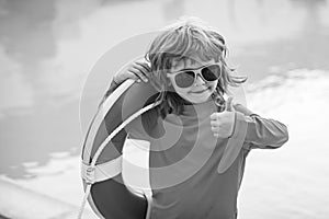 Child with Lifebuoy in swimming pool. Children playing in the pool. Healthy kids lifestyle. Summer kids vacation.