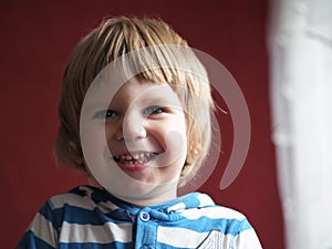 A child with light hair of European appearance smiles